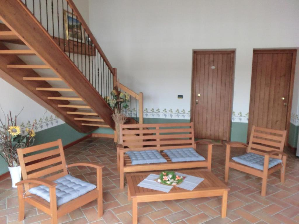 une chambre avec trois chaises et un escalier dans l'établissement Agriturismo Domus Rustica, à Cormòns