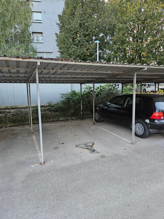 a car parking lot with a car parked under a carport at Apartman Sany in Bihać