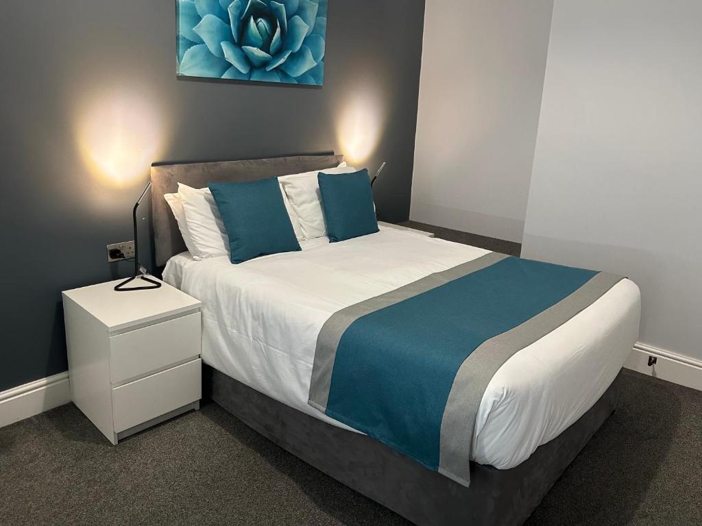a bedroom with a bed with blue and white at Arlan House, Central Basingstoke Hotel in Basingstoke