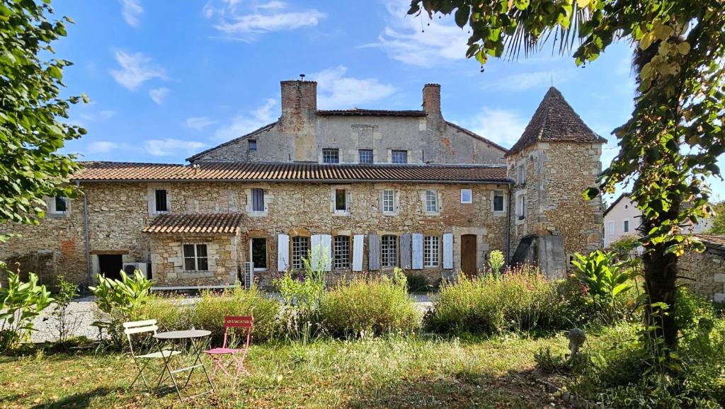 an old stone building with chairs and a table at Château Arche d'Aure in Vicq-dʼAuribat