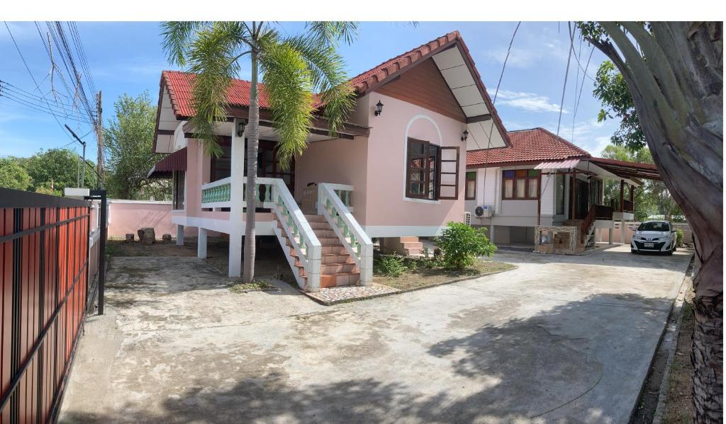 een huis met een palmboom ervoor bij Happy Home Villa 1 in Nathon Bay