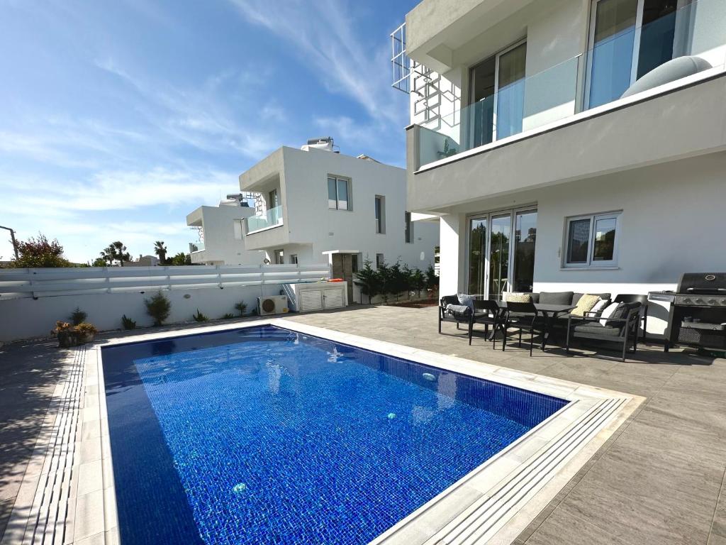 a swimming pool in front of a house at Protaras LUX Villa, Swimming pool, BBQ grill, Near beach in Protaras