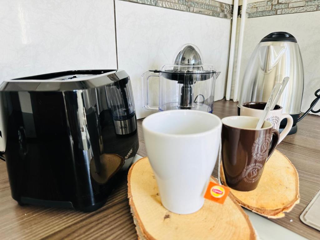 eine Kaffeemaschine und zwei Tassen auf der Theke in der Unterkunft SAINT DENIS 2 Chambres , 8min Porte Chapelle-8min Stade de France in Saint-Denis
