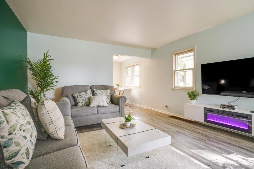 Cozy Minneapolis Duplex - 10 Mi to Downtown! في مينيابوليس: غرفة معيشة مع أريكة وتلفزيون