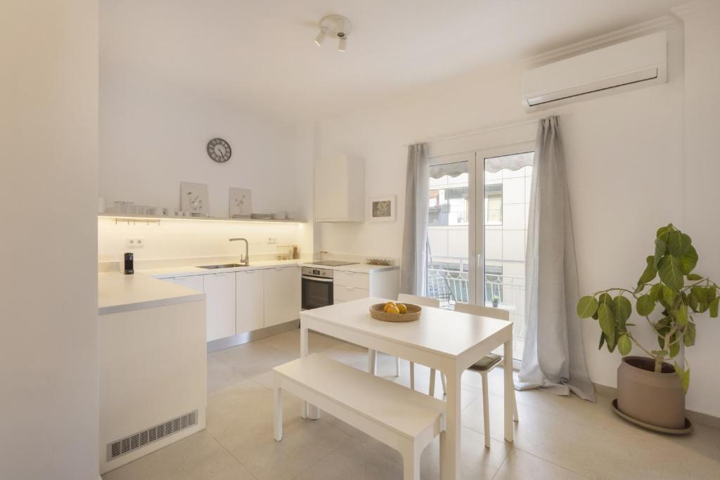 a white kitchen with a white table and a white table at Kerameikou25 large in Athens