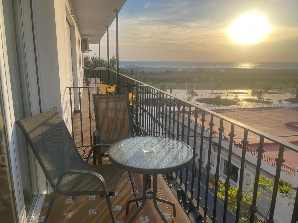 a balcony with a table and chairs and a view of the ocean at Apartamento Mirador del Atlántico in Conil de la Frontera