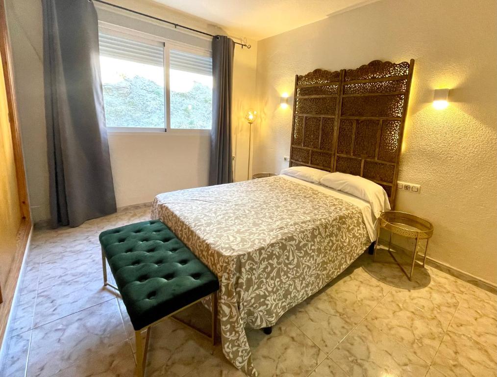 1 dormitorio con 1 cama, 1 silla y 1 ventana en CHINASOL Low Cost en Almuñécar