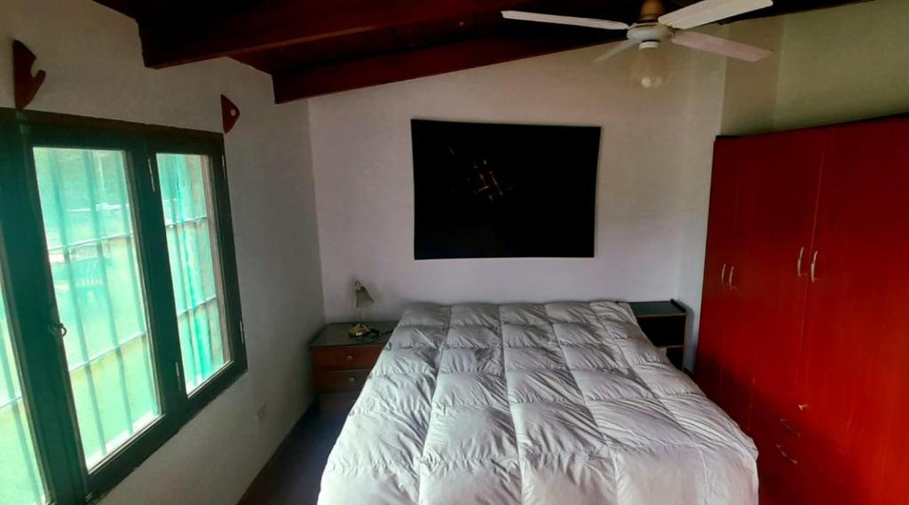 - une chambre avec un lit et un ventilateur de plafond dans l'établissement Lugar clave, à Cerrillos