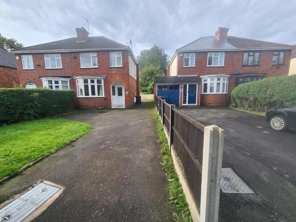 a house with a car parked in front of a driveway at L & J Escapes - 8 Bedrooms suitable for Contractors and Families- Private parking available for 6 vehicles in Coseley