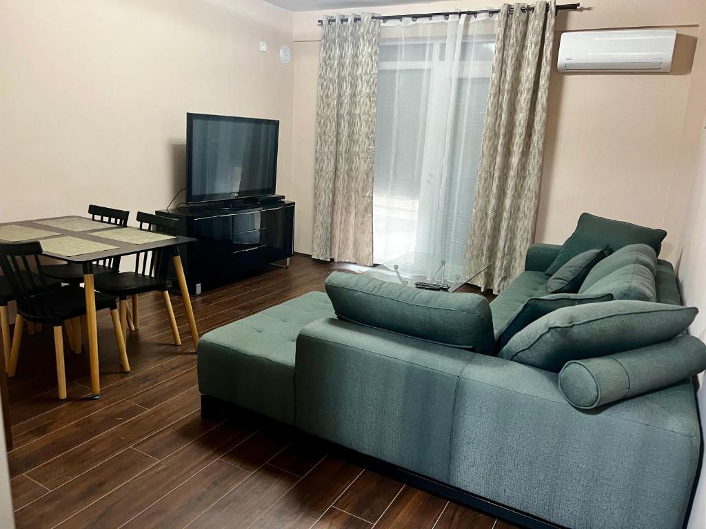 uma sala de estar com um sofá verde e uma mesa em Juliya Apartment em Kavadarci