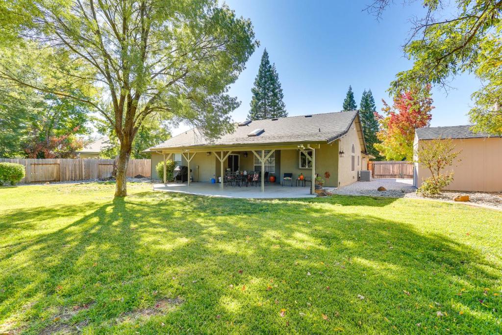 a house with a tree in the yard at Charming Redding Home with Furnished Patio! in Redding