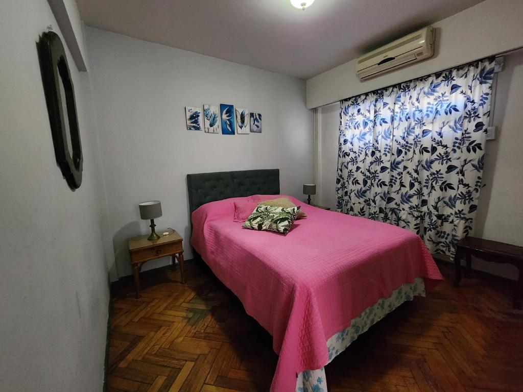 1 dormitorio con cama rosa y manta rosa en Departamento Palermo Hasta 4 en Buenos Aires