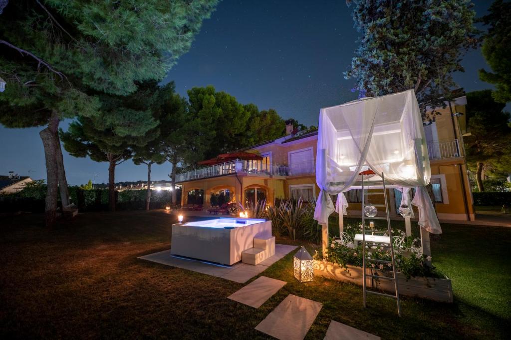 una casa con una mesa en el patio por la noche en Tra gli Alberi e il Mare en Sirolo