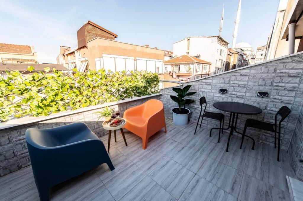 Un balcón con sillas y mesas en un edificio en Dach Wochnung mit Terrasse, en Estambul