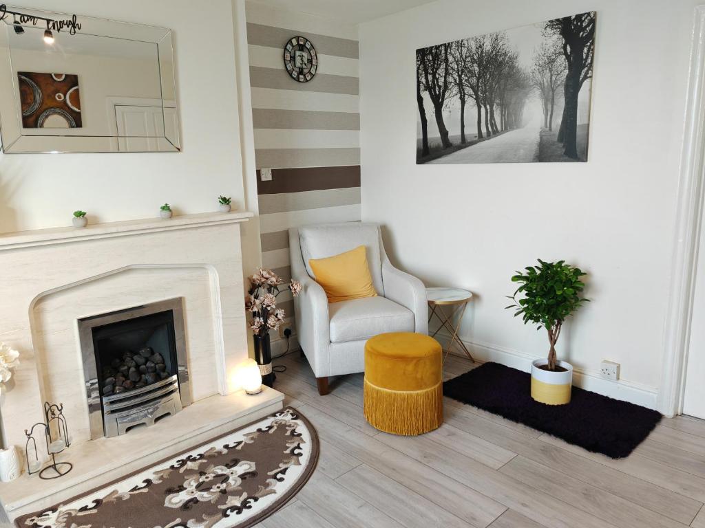 a living room with a chair and a fireplace at Stylish 1 bedroom Haven in Coventry