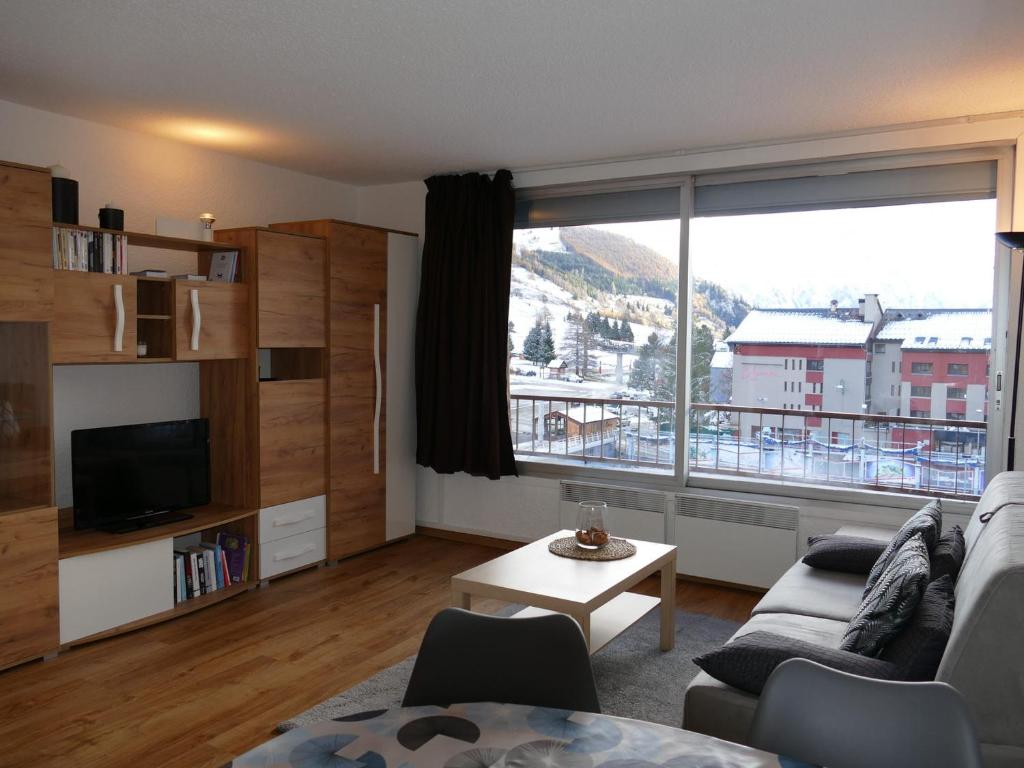 un salon avec un canapé et une grande fenêtre dans l'établissement Les 2 Alpes - Studio rénové 4 pers, pied des pistes, parking - FR-1-546-53, à Les Deux Alpes