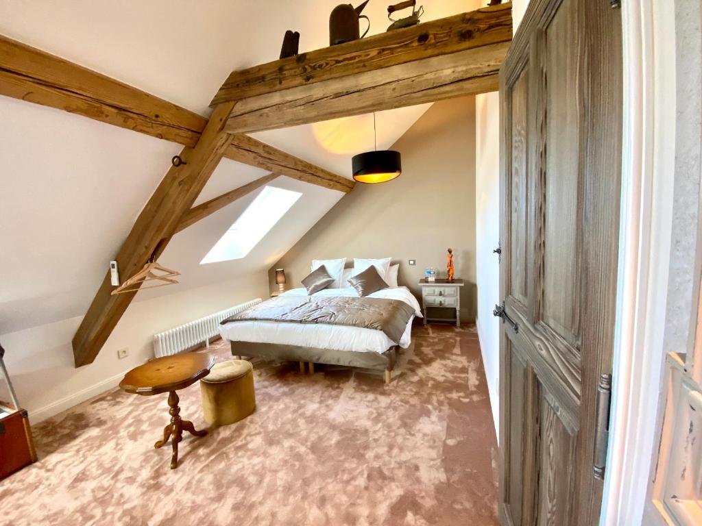 a bedroom with a bed and a vaulted ceiling at Le Gîte de la Grange in La Wantzenau