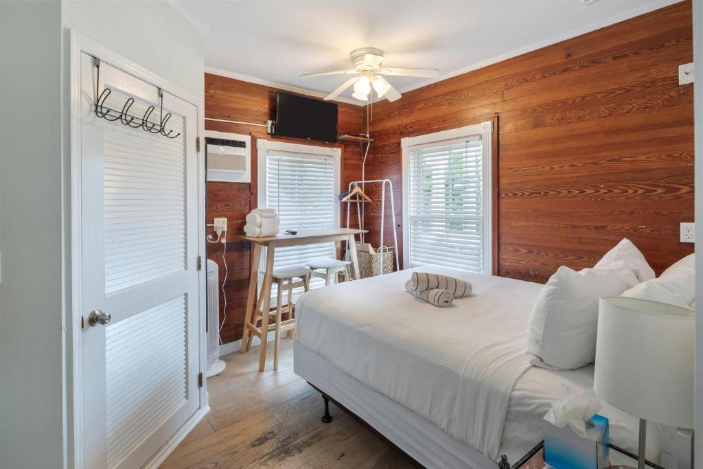 a bedroom with a bed and a table in a room at Carey's Corner #10 by Brightwild in Key West