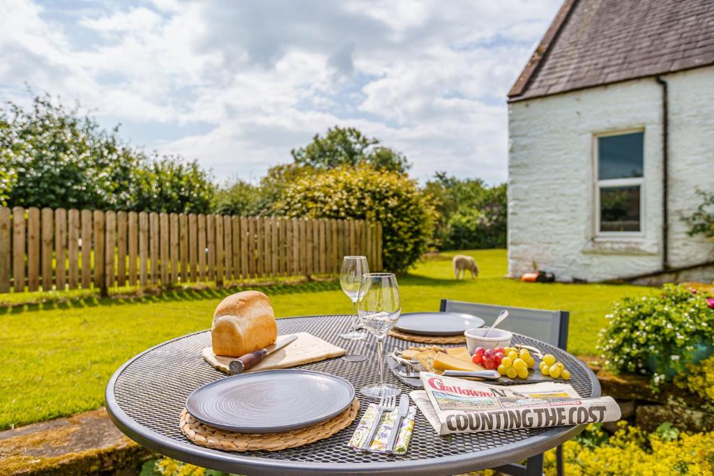 una mesa con platos de comida en un patio en The Cheeseloft - Spacious one bed with terrace, en Kirkcudbright