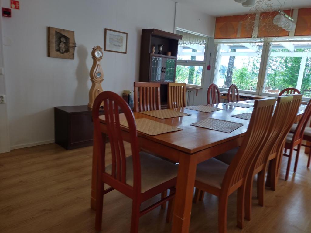 a dining room with a wooden table and chairs at Saarnimaja in Hämeenlinna
