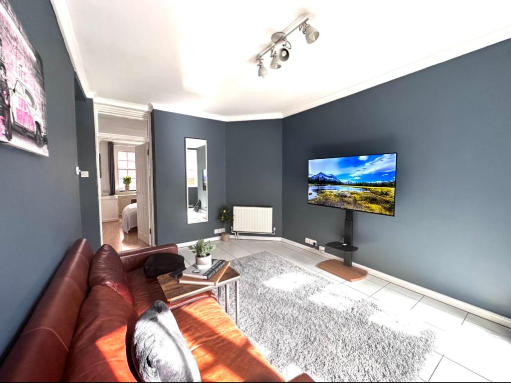 a living room with a couch and a flat screen tv at Kings Cross Two-Bedroom Apartment for 5 Guests Near Tube伦敦 in London