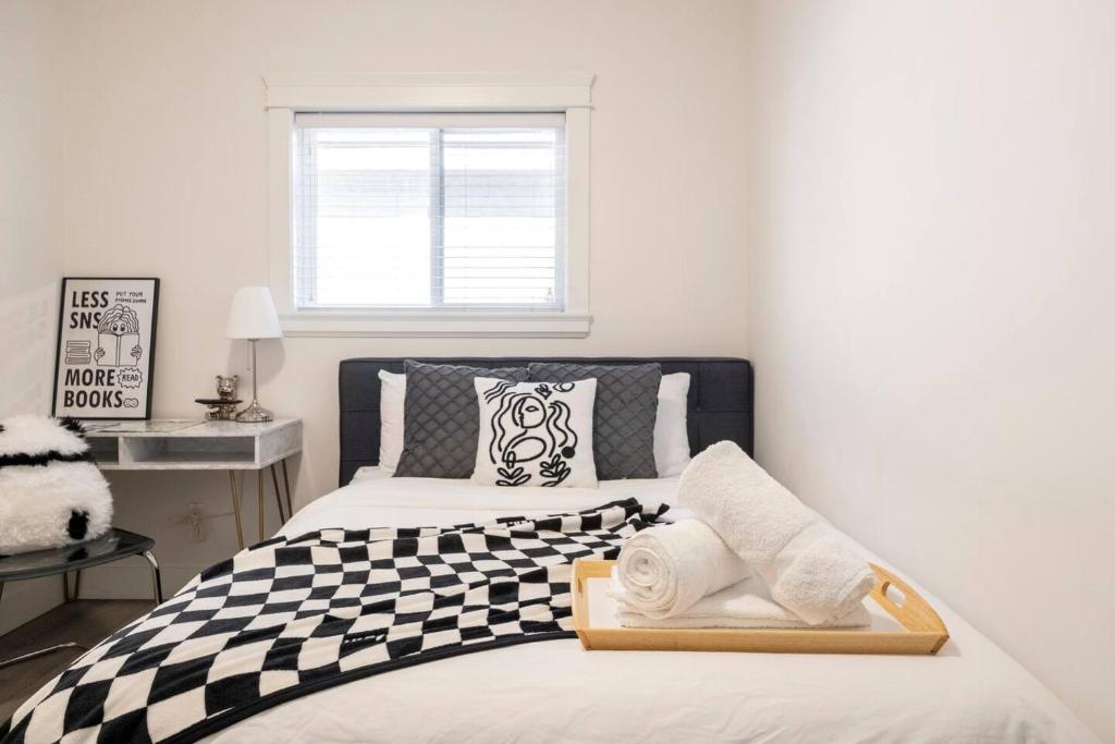 een slaapkamer met 2 bedden en zwarte en witte kussens bij Si & Daniel Home Near YVR Airport & Skytrain Separate Entry Free Parking in Richmond