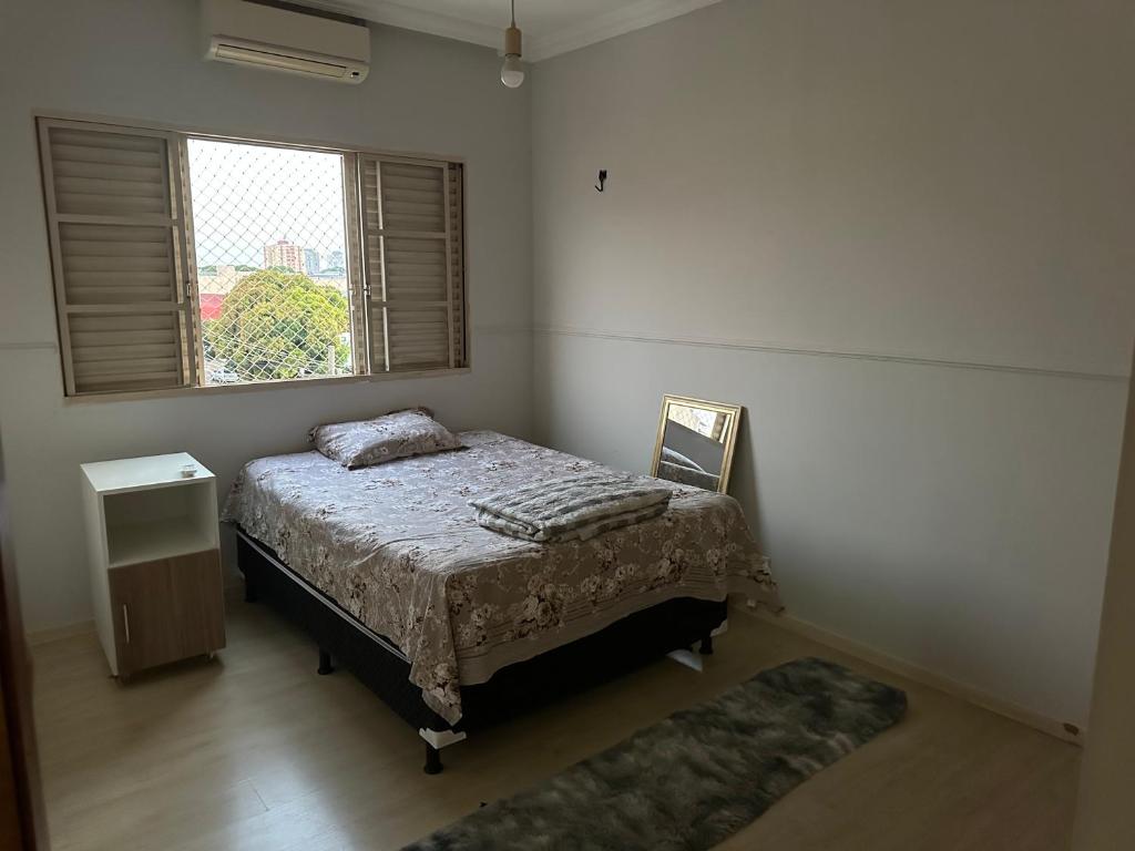 um pequeno quarto com uma cama e uma janela em Não disponível mais em Campo Grande