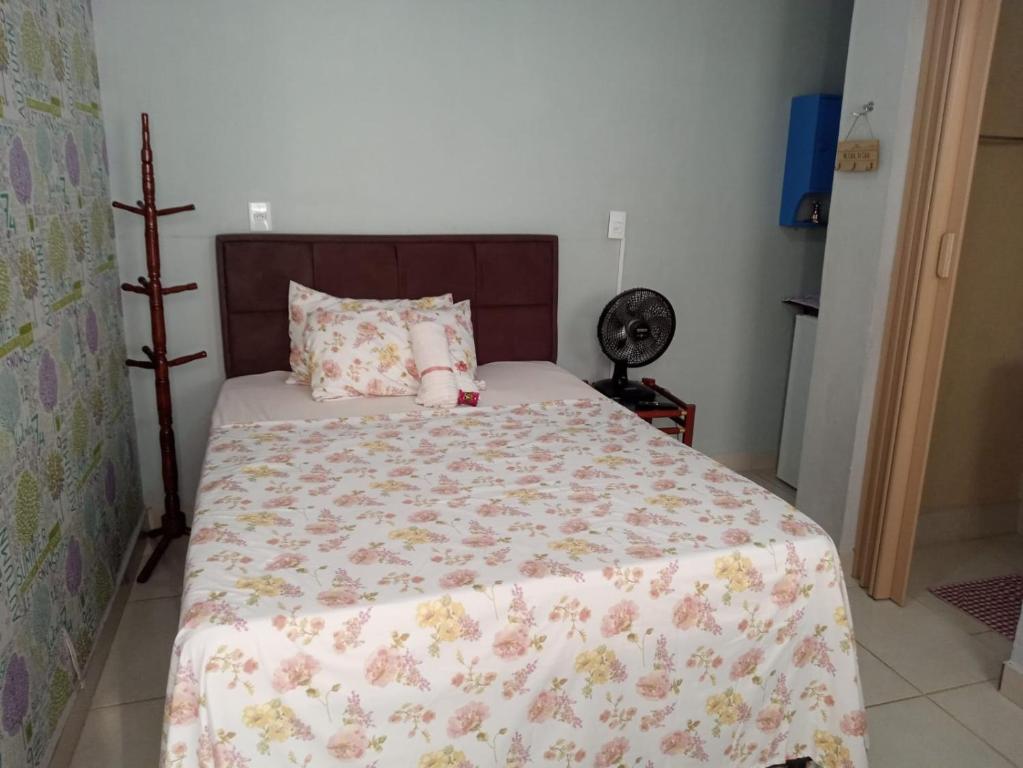 um quarto com uma cama com colcha floral em Suite para seu descanço em Indaiatuba