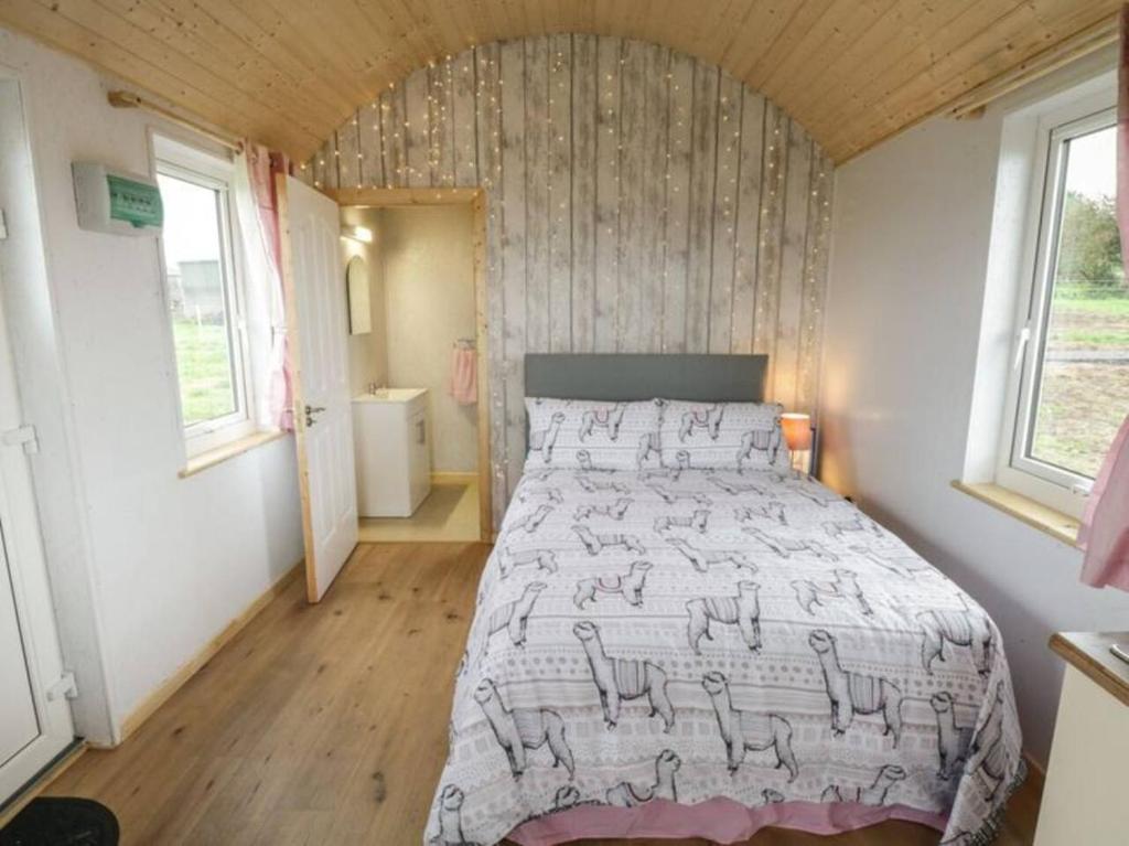 Tempat tidur dalam kamar di The Lazy Llama Farm Stay Shepherd Hut