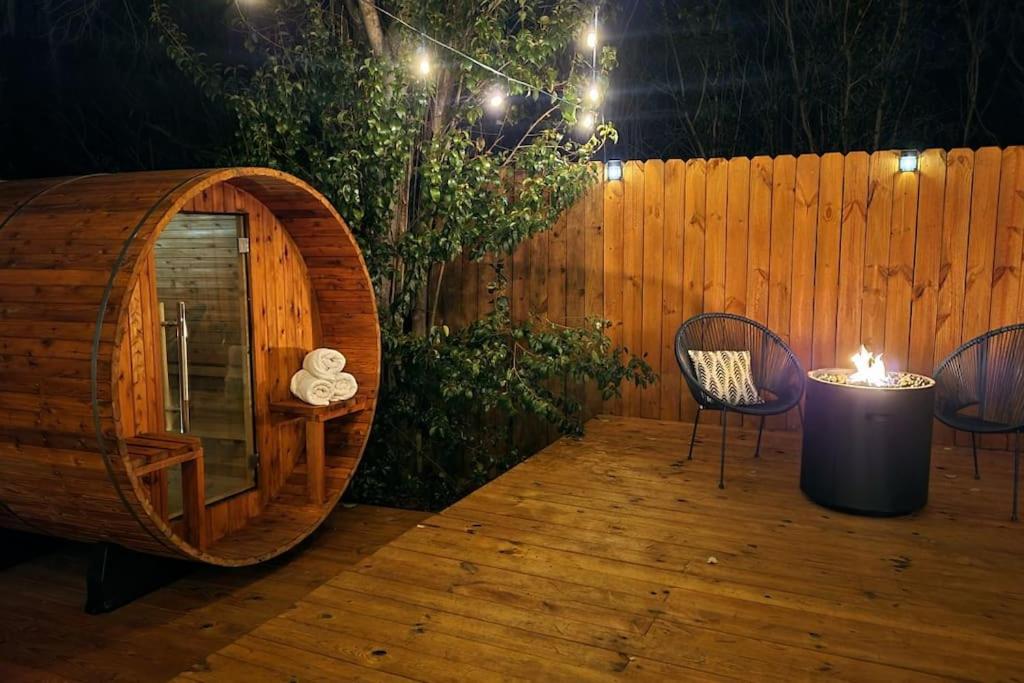 una terraza de madera con un barril y sillas de madera y una valla de madera en 5th St Getaway w Sauna Hot tub Firepit & Game Room, en Waco