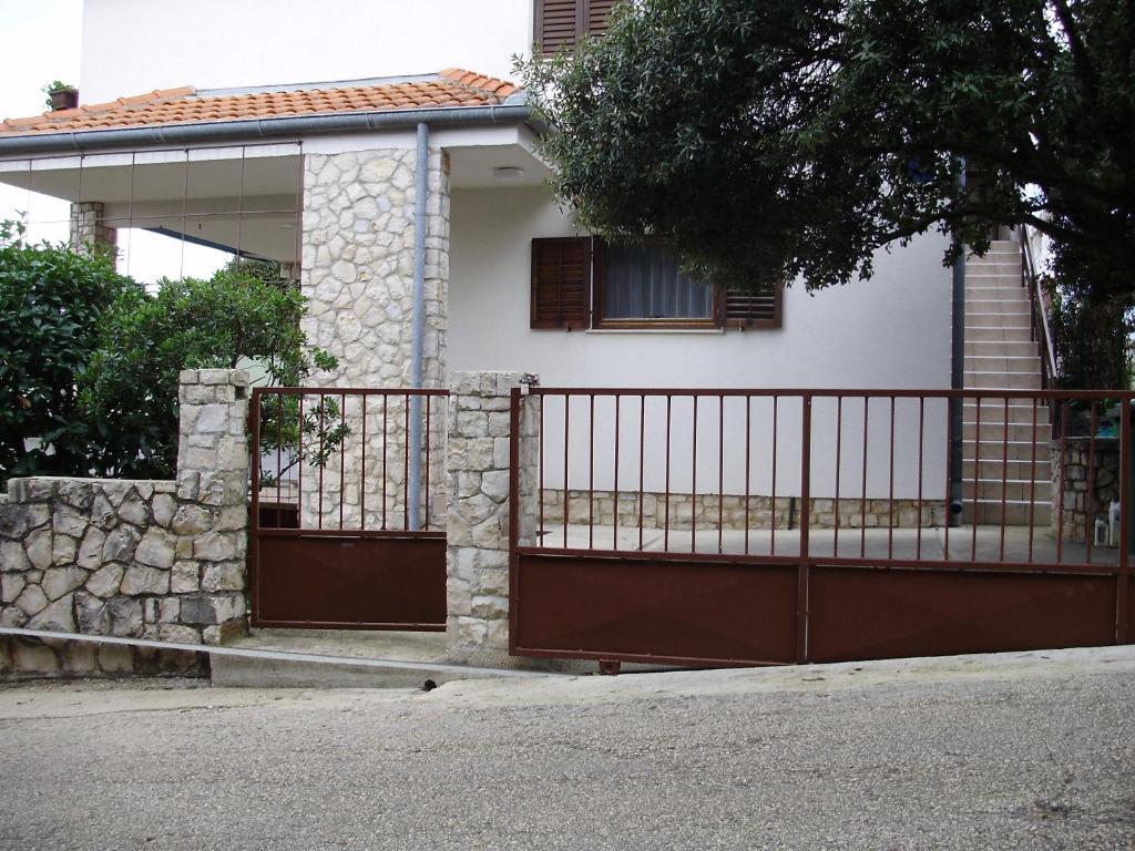 ein Haus mit einem Tor davor in der Unterkunft Apartments Pero in Kožino