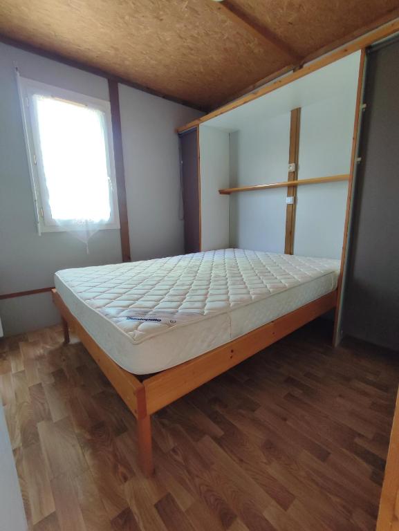 a large bed in a room with a window at Grand chalet en bois climatisé avec vue sur le lac in Saramon