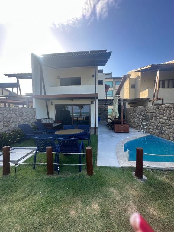 a villa with a swimming pool and a house at Ekoara Residence bangalô 07 in Porto De Galinhas