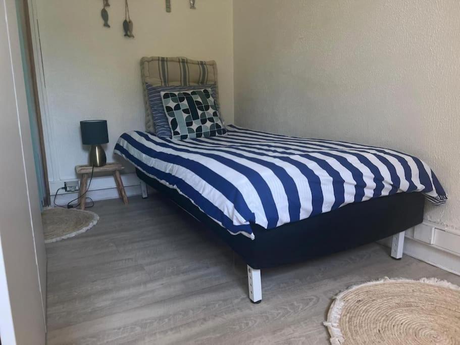 een slaapkamer met een bed met een blauw en wit dekbed bij Studio Serenity - Hyper Centre et Proche Plage - Bus in Duinkerke
