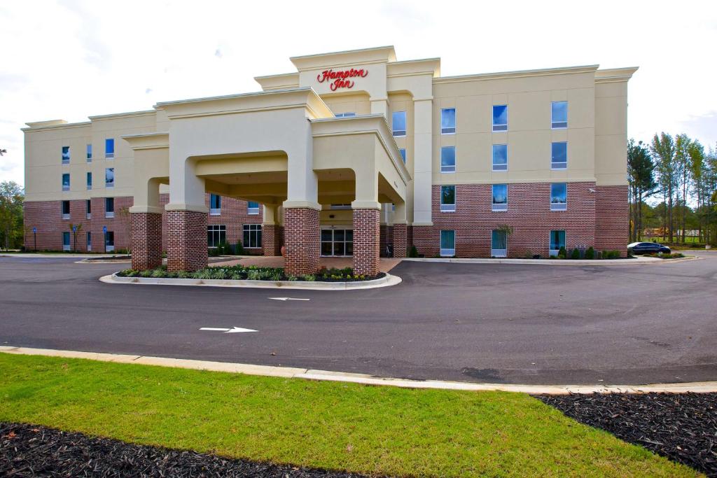 un grand bâtiment de bureau avec un parking dans l'établissement Hampton Inn Atlanta McDonough, à McDonough