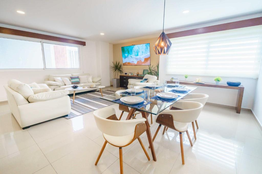 カンクンにあるStylish Three-Bedroom Condo w/Poolのダイニングテーブルと椅子のあるリビングルーム