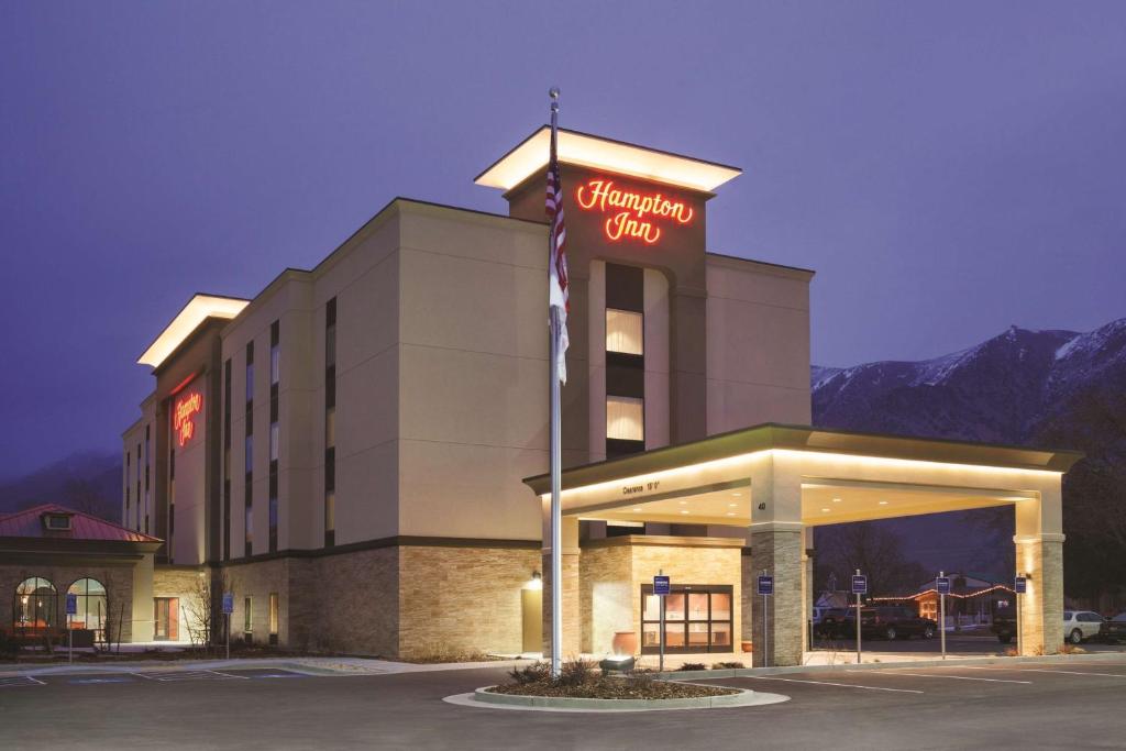 a hotel with a sign on the front of a building at Hampton Inn Brigham City in Brigham City