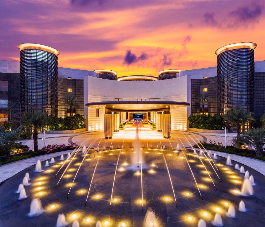 a hotel with a fountain in front of a building at Thousand Cranes Sanya Yazhou Bay Int'l Exchange Centre in Sanya