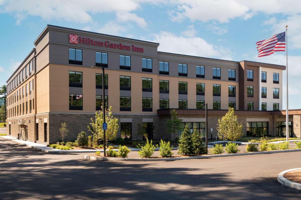 a building with an american flag in front of it at Hilton Garden Inn Boston Canton, Ma in Canton