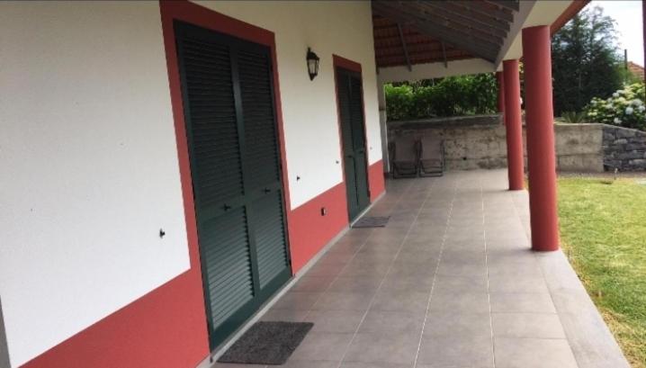 a building with red and green doors and a patio at Quinta Sol II Sea in Camacha