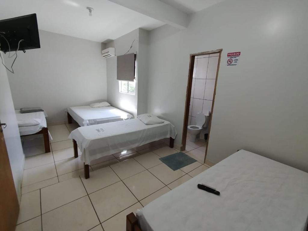a hospital room with two beds and a mirror at Hotel Oliveira 44 in Goiânia