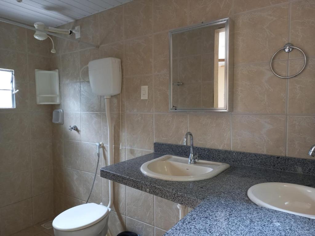 bagno con lavandino, servizi igienici e specchio di Pousada Rota Do Beija Flor PACOTI-CE a Pacoti