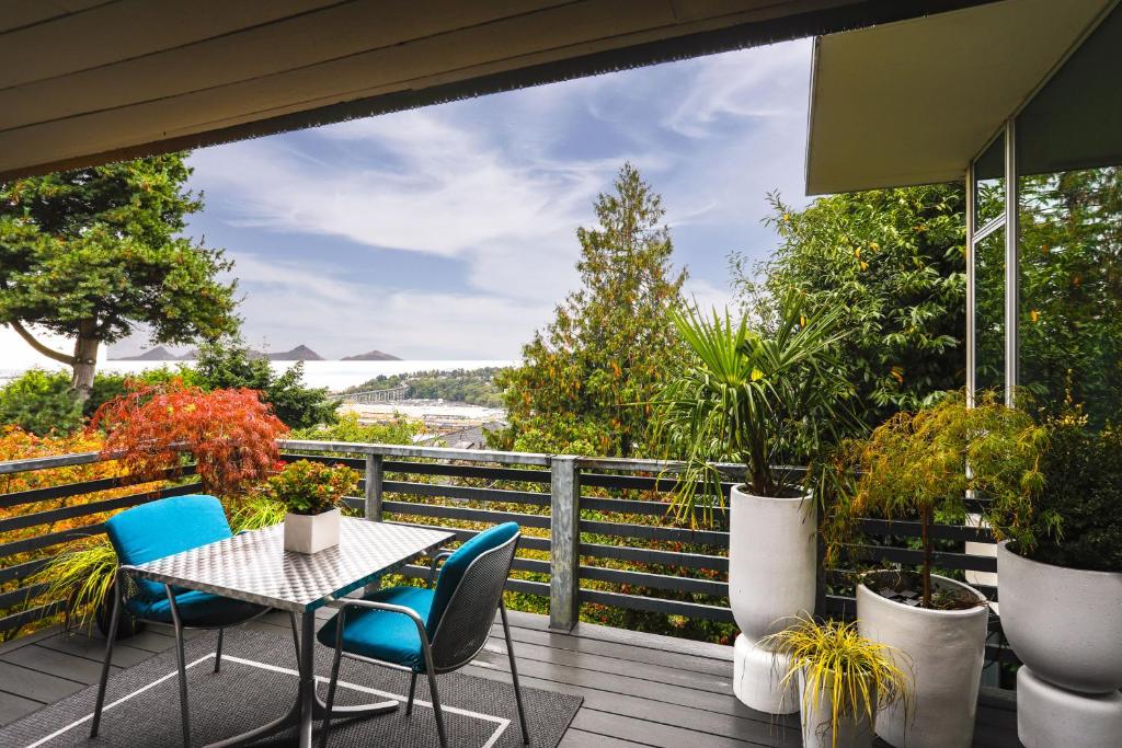 a table and chairs on a deck with plants at Stylish Seattle Vacation Rental with Water View in Seattle