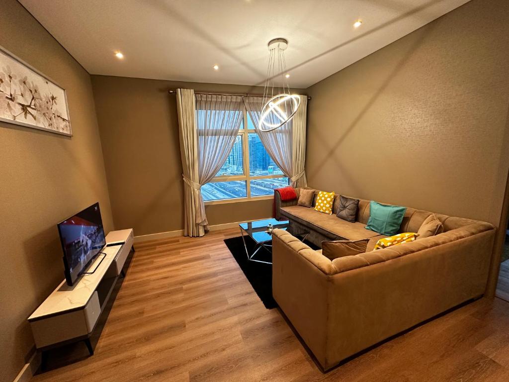 smilehomesdxb في دبي: غرفة معيشة مع أريكة وتلفزيون