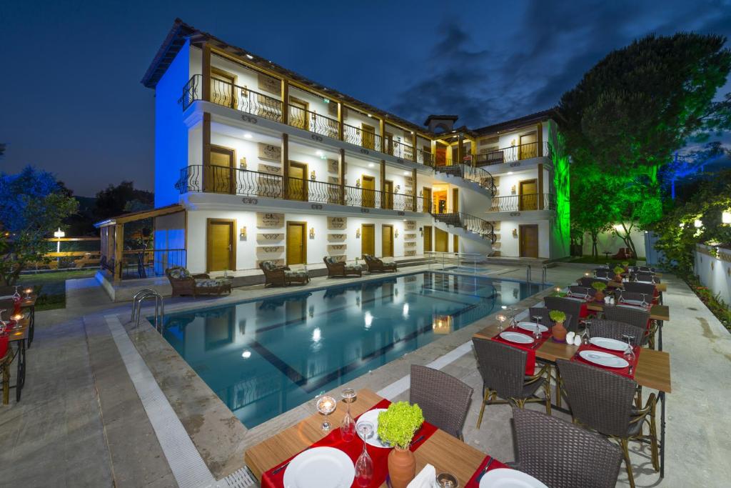 a hotel with a swimming pool in front of a building at Amore Hotel Teki̇rova in Tekirova