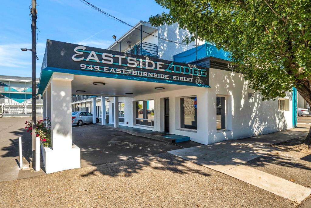 a white building with a sign on the front of it at Eastside Lodge in Portland