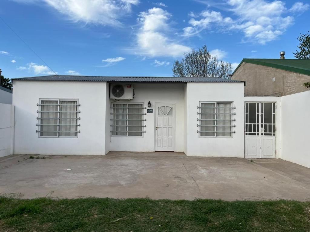 una casa blanca con dos puertas y un patio en Hermosa casa en Gral. Villegas en General Villegas