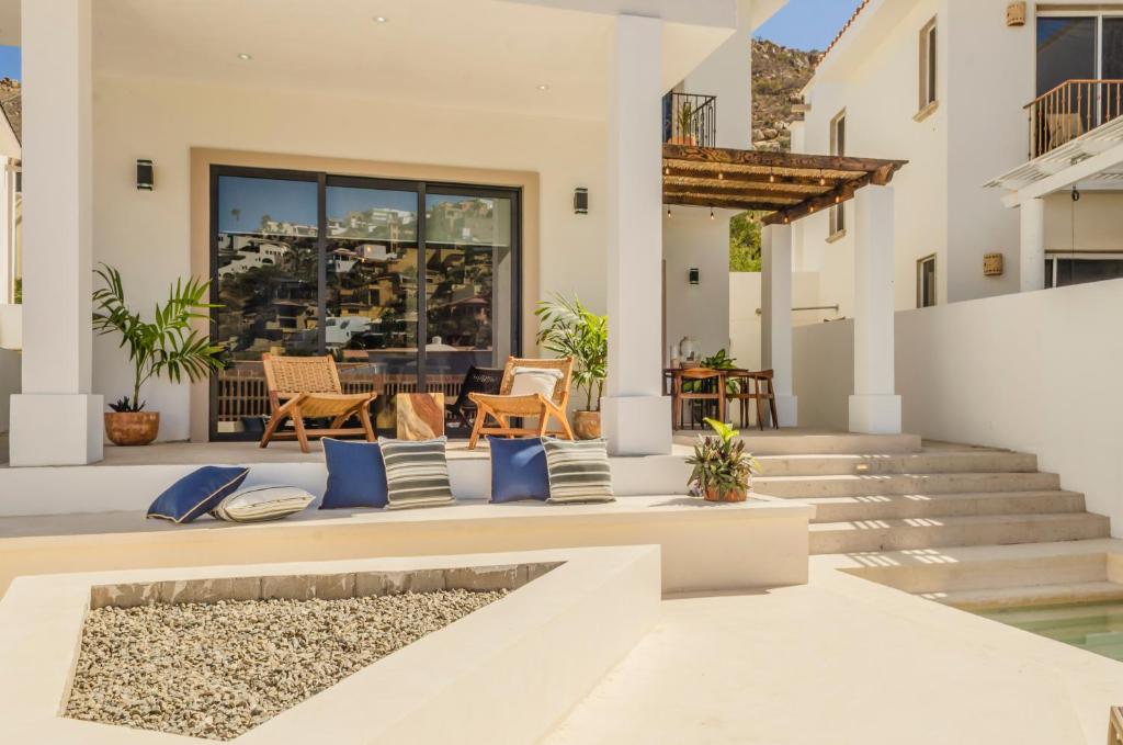 a white house with a patio with blue pillows at Casa Gallo, Luxurious Private 3Bd Villas in the heart of Cabo in Cabo San Lucas