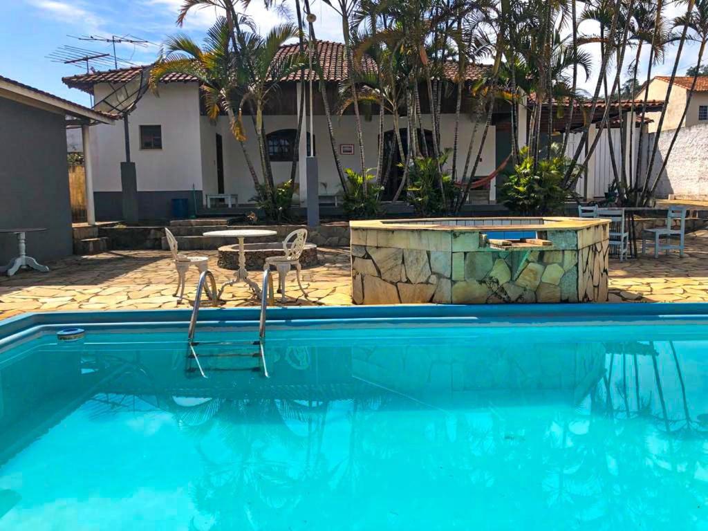 uma piscina em frente a uma casa em Casa de campo com piscina, mesa de bilhar e 3 quartos em Itanhandu