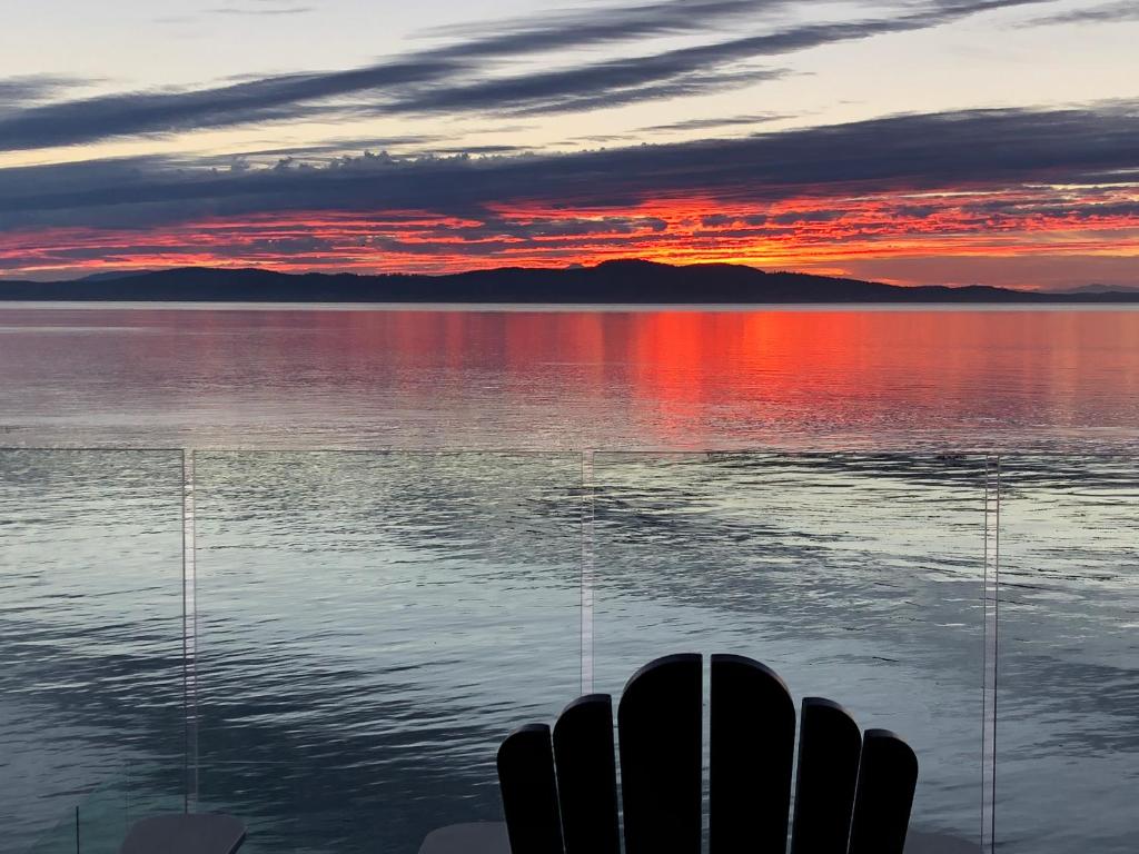 una vista de la puesta de sol sobre un cuerpo de agua en Ocean Front Private Suite en Victoria